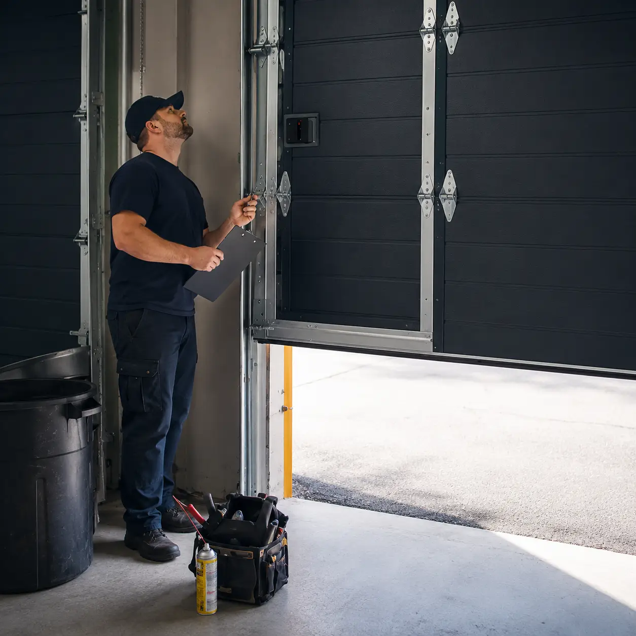 Technician performing preventive garage door maintenance